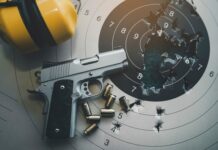 NEW Gun Law Faces Major Constitutional Challenge… A handgun placed on a shooting target with bullet holes and spent cartridges nearby