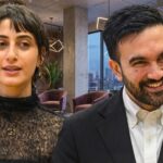 Mamdani BUSTED Using Taxpayer Mansion for Radical Endorsement…. Two professionals engaged in conversation in a modern office setting