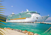 Cruise TRAGEDY: Teen Faces Federal MURDER Charges Large cruise ship docked near turquoise water and foliage.