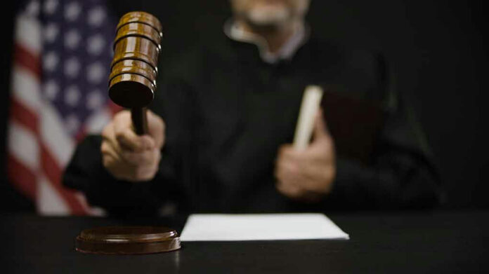 2175831985 Judge hitting gavel in courtroom.