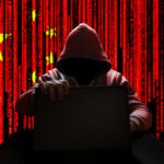 White House Shuts Door on Superhack AI A hooded figure sitting at a desk with a laptop, against a red background featuring the Chinese flag