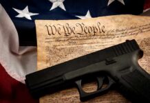 State Court Rebels On Guns Handgun on U.S. Constitution with American flag backdrop
