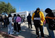 Students standing outside a high school entrance