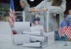 Court Chaos Over Mail Votes Explodes Person casting a ballot into a clear box at a polling station