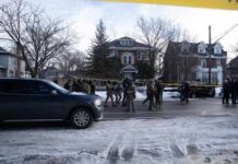 Law enforcement officers in tactical gear at a crime scene surrounded by police tape