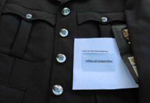 Resignation letter on black uniform jacket.