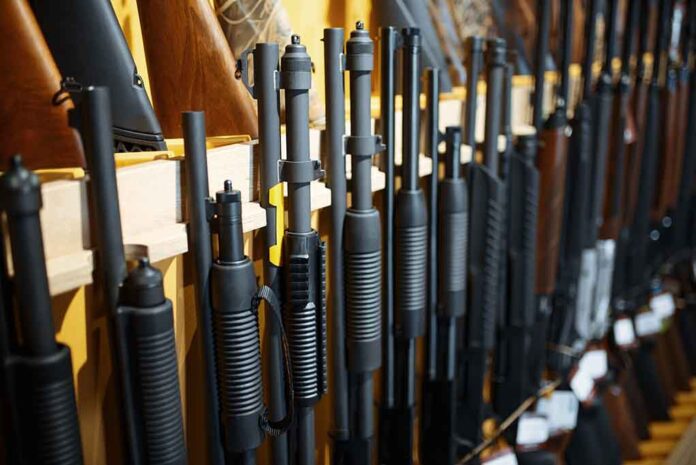 Rows of shotguns displayed on a wooden rack.